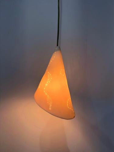 an orange light is hanging from a ceiling at The Jazz Suite in Aegina Town