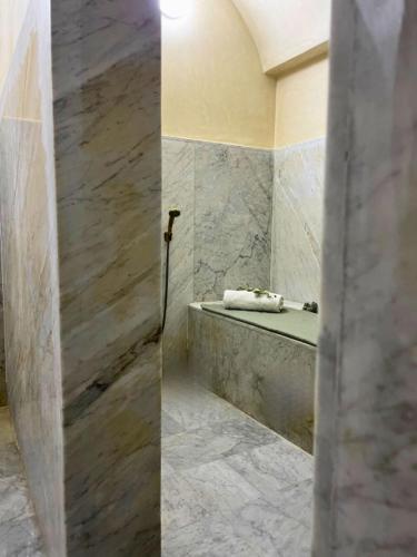 a bathroom with a sink and a shower with marble walls at Shams Ourika in Sbiti