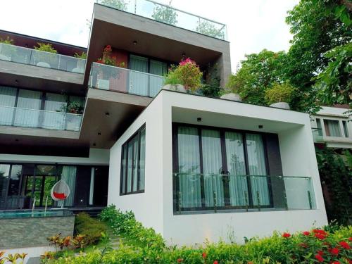 a building with plants on the balconies of it at FLAMIGO ĐẠI LẢI RESORT - Villa View Hồ in Ngọc Quang