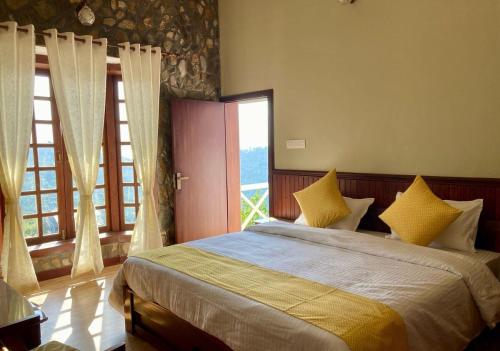 a bedroom with a large bed with yellow pillows at Hridayam Homestay near Mukteshwar in Mukteswar