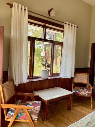 a room with a window with a bench and a table at Hridayam Homestay near Mukteshwar in Mukteswar