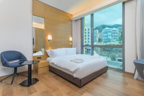 a hotel room with a bed and a desk and a window at Jounieh Living - Residences by Local Host in Ed Dkârîne