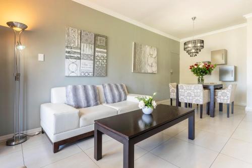 a living room with a couch and a table at Devonvale Golf & Wine Estate in Stellenbosch
