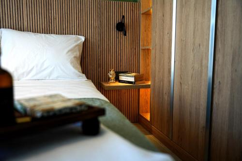 a bedroom with a white bed and a wooden wall at SOHO Residence in Selcuk