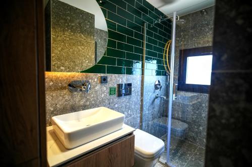 a bathroom with a sink and a shower and a toilet at SOHO Residence in Selcuk