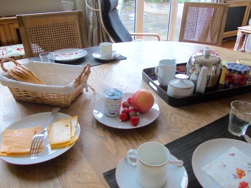 een houten tafel met borden met eten erop bij B&B Chambre Chocolat in Brussel