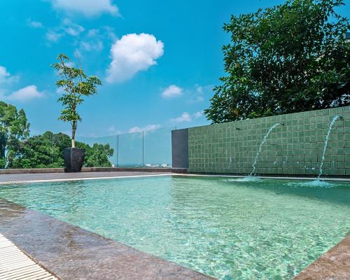 a swimming pool with a fountain in front of a building at Majestic Sanctuary Homestay Taiping with Netflix - 2 Carpark in Taiping