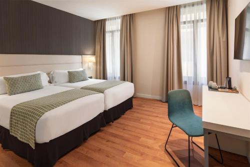 a hotel room with a bed and a chair at Catalonia Plaza Mayor Salamanca in Salamanca