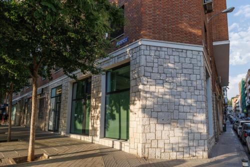 a brick building with large windows on a street at WE MADRID STUDIOS centro in Madrid