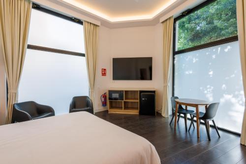 a bedroom with a bed and a table and chairs at WE MADRID STUDIOS centro in Madrid