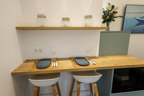 a kitchen with a counter with stools and a table at WE MADRID STUDIOS centro in Madrid
