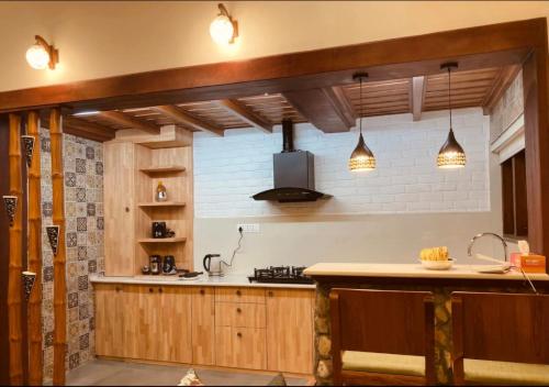 a kitchen with wooden cabinets and a counter top at Hridayam Homestay near Mukteshwar in Mukteswar