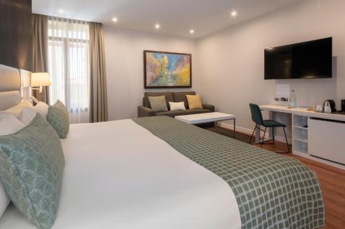 a hotel room with a bed and a living room at Catalonia Plaza Mayor Salamanca in Salamanca