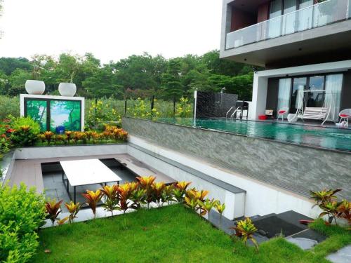 a house with a pool and a table on a patio at FLAMIGO ĐẠI LẢI RESORT - Villa View Hồ in Ngọc Quang