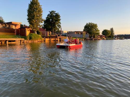 a small boat in the water near a dock at WM GEDER Ferienwohnungen Werner in Lebring