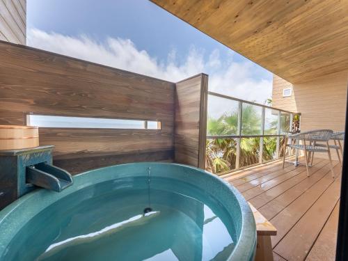 a hot tub on the deck of a house at Livemax Resort Inami Seafront in Inami