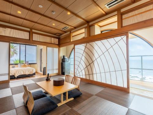 a living room with a view of the ocean at Livemax Resort Inami Seafront in Inami