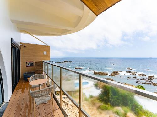 a balcony with a view of the ocean at Livemax Resort Inami Seafront in Inami