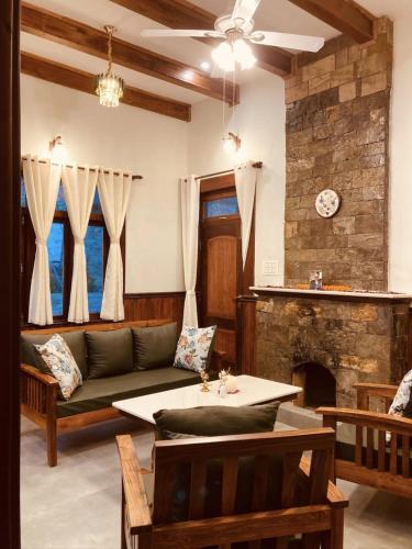 a living room with a couch and a fireplace at Hridayam Homestay near Mukteshwar in Mukteswar