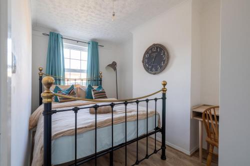 a bedroom with a bed and a clock on the wall at Cyrus House in Dartford