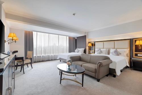 a hotel room with a bed and a couch at ARTOTEL Suites Aquila - Bandung in Bandung