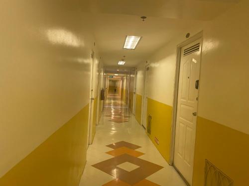 un couloir vide avec un long hall avec du carrelage au sol dans l'établissement happynest Budget Family 754, à Tagaytay