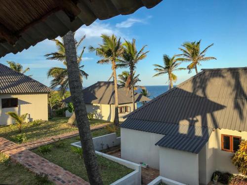 a view from the balcony of a house with palm trees at Ventos do Mar Lodge in Inhambane