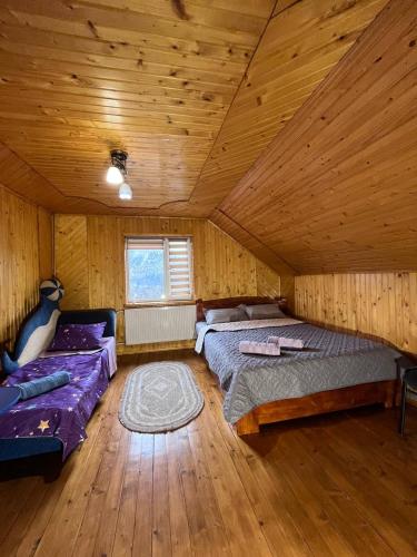 une grande chambre avec deux lits et un canapé dans l'établissement Затишок Карпат, à Vygoda