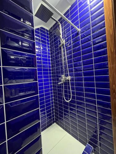 une salle de bain carrelée bleue avec une douche dans l'établissement Затишок Карпат, à Vygoda