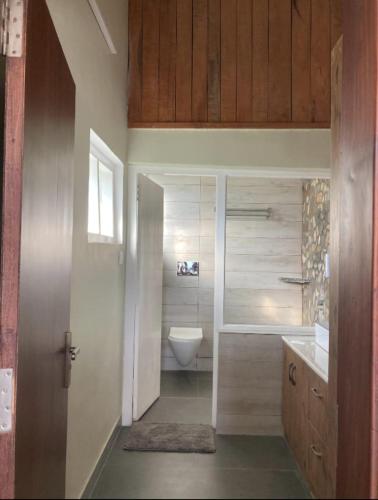 a bathroom with a toilet and a bath tub at Hridayam Homestay near Mukteshwar in Mukteswar