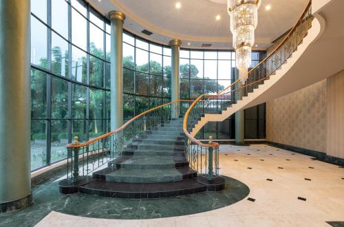 a spiral staircase in a building with windows at ARTOTEL Suites Aquila - Bandung in Bandung