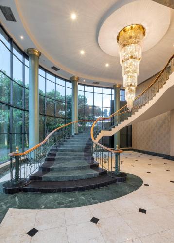 a staircase in a building with a chandelier at ARTOTEL Suites Aquila - Bandung in Bandung