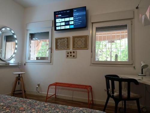a room with a bed and a television on the wall at Women Only - Solo Mujeres in Seville