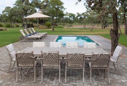 a table and chairs next to a swimming pool at Die Boskamp Self-Catering Bush Retreat in Marble Hall