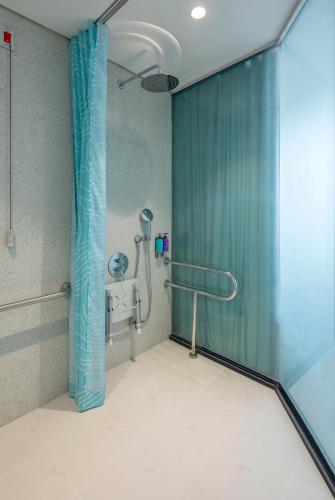 a shower with a blue shower curtain in a bathroom at Tru by Hilton Thai Binh City Centre in Thái Bình