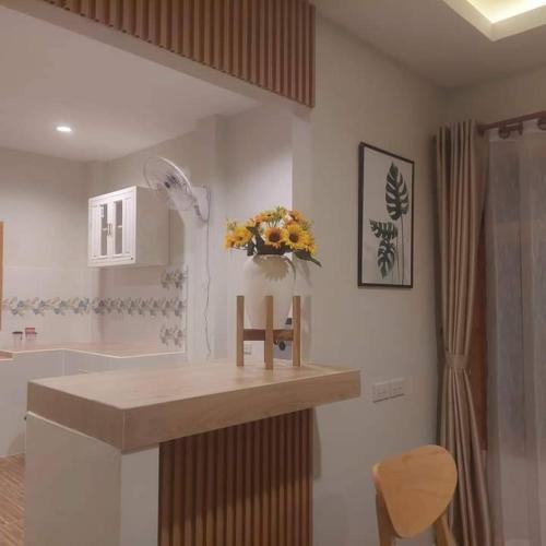 a kitchen with a counter with a vase of flowers on it at Minimal Pool Villa Chiang Mai in Chiang Mai