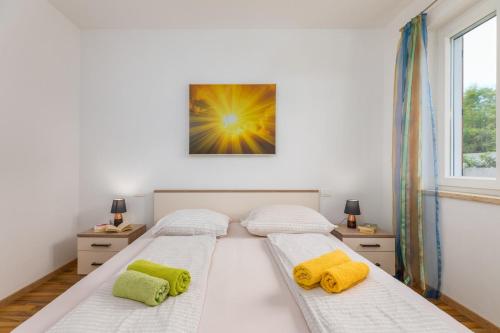 a bedroom with two beds with yellow pillows on them at Villa Katharina in Krmenjak