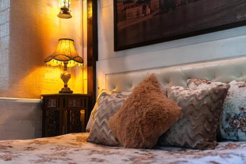 a teddy bear sitting on a bed next to a lamp at RODEO 228 - Rustic & Vintage 3BHK Villa with Pool in Jambrung 