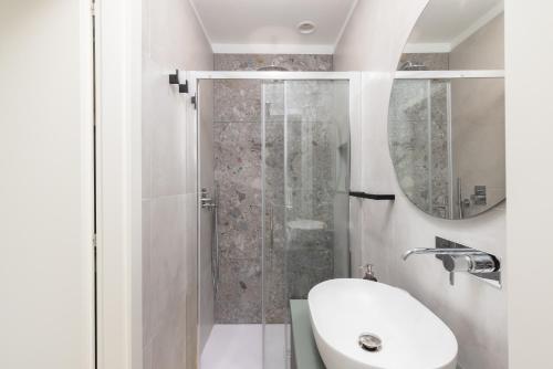 a white bathroom with a shower and a sink at Segrate - Milano Due Appartamento di Lusso con Vista Lago in Segrate