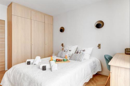 a bedroom with a white bed with a tray of food on it at 606 Aaron Suite - Apartment in Paris 7th in Paris