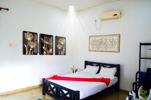 a bedroom with a bed with two pictures on the wall at Hotel Water Nest in Etagama