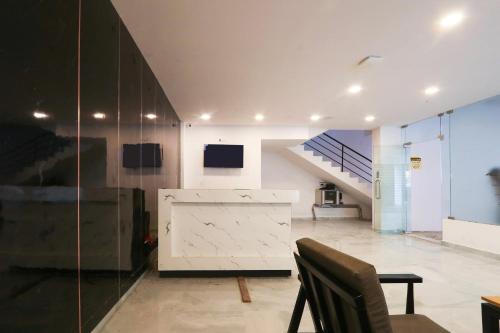 a room with a staircase and a table and a chair at Super townhouse Dilshuk Nagar in Hyderabad
