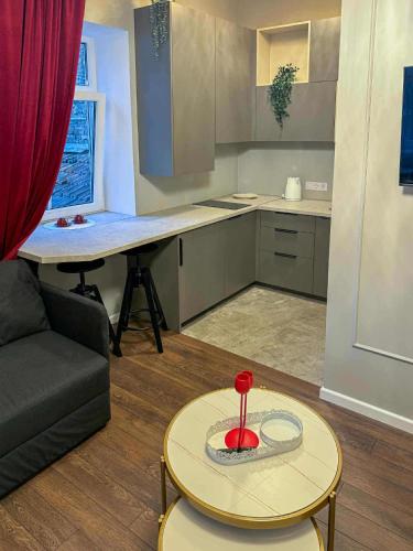 ein Wohnzimmer mit einem Tisch und einer Küche in der Unterkunft Jacuzzi overlooking the tower in Vilnius