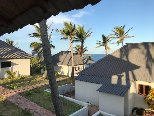 a view from the balcony of a house with palm trees at Ventos do Mar Lodge in Inhambane