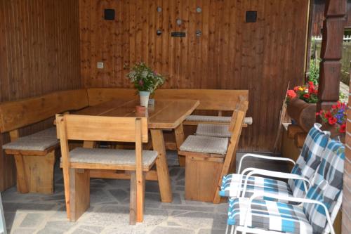 a wooden table and chairs on a patio at Ferienwohnung Seebauer in Ramspau