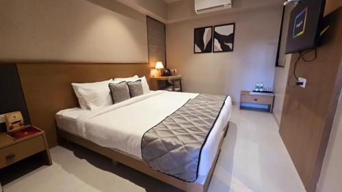 a bedroom with a large bed and a television at SIVANTA by BOMBAY GROUP OF HOTELS NAGPUR in Nagpur
