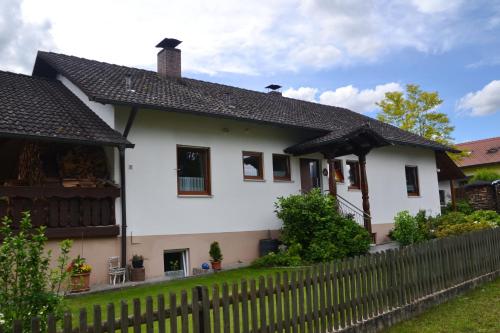 a white house with a fence in front of it at Ferienwohnung Seebauer in Ramspau
