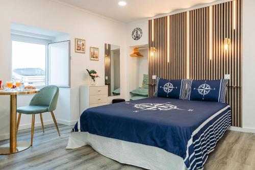 a bedroom with a bed and a table and a chair at Seixal Yachting Bay Studio in Seixal