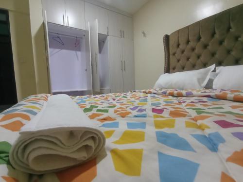 a bedroom with a bed with a colorful bedspread at Montesita Airbnbs in Nairobi
