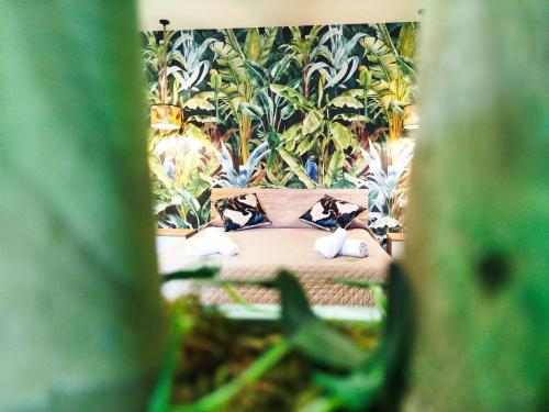 uma cama com dois travesseiros em um quarto com plantas em Avusa Home em Palermo